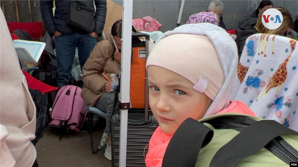 Sentada en la maleta que lleva su familia espera esta pequeña refugiada ucraniana en la entrada de la garita de San Ysidro, en Tijuana, donde desde marzo empezaron a cruzar los refugiados ucranianos. (Tijuana, México-April 5, 2022-Celia Mendoza)