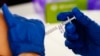 FILE - A health worker administers a dose of a Moderna COVID-19 vaccine during a vaccination clinic in Norristown, Pa., Dec. 7, 2021.