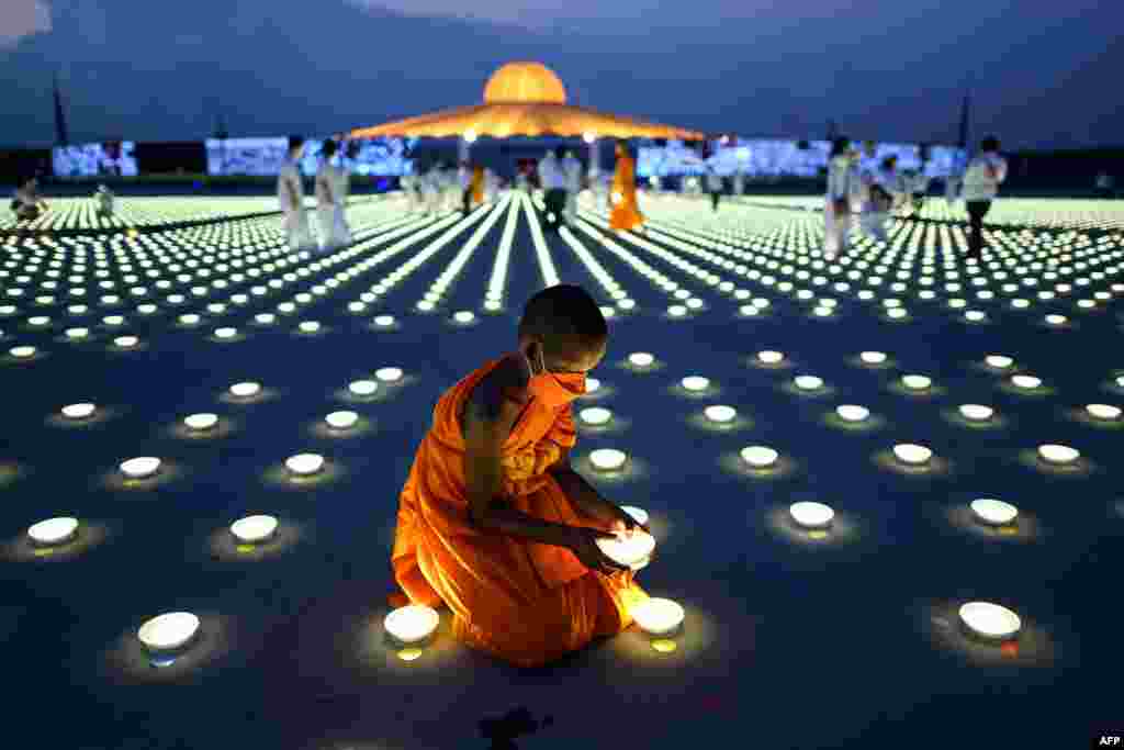 A young Buddhist monk arranges an LED light as part of Earth Day celebrations at the Wat Dhammakaya Buddhist temple in Pathum Thani province, north of Bangkok.