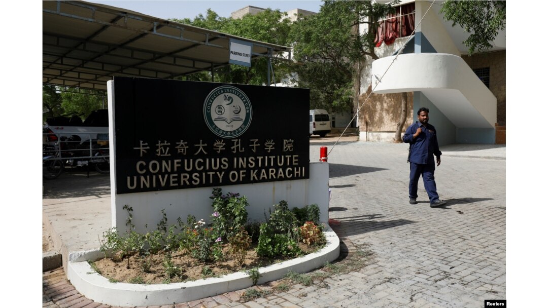 A security guard walks after a blast near a passenger van (not pictured) at the entrance of the Confucius Institute University of Karachi, Pakistan, April 26, 2022.