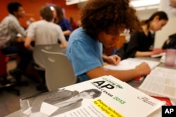 FILE - Twelfth grade students work in their AP Physics class at Woodrow Wilson High School in Washington, Friday, Feb. 7, 2014. (AP Photo/Charles Dharapak)