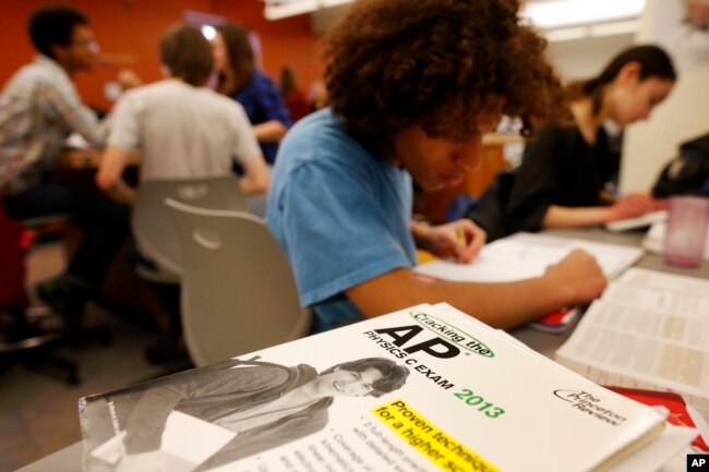 FILE - Twelfth grade students work in their AP Physics class at Woodrow Wilson High School in Washington, Friday, Feb. 7, 2014. (AP Photo/Charles Dharapak)