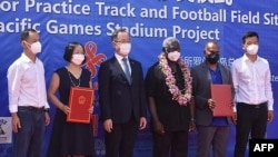 所罗门群岛总理索加瓦雷（右三）与中国驻所罗门群岛大使李明（左三）与其他官员在霍尼亚拉中国援建的体育馆项目开工仪式上合影。（2022年4月22日）