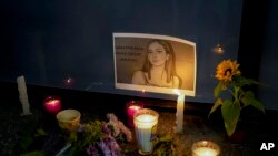 FILE - Candles and flowers surround an image of Debanhi Escobar during a protest against the disappearance of her and other missing women in Mexico City, April 22, 2022.