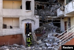 Rescuers work to remove debris from a building that was hit in a military strike, amid Russia's invasion, in Odesa, Ukraine, April 24, 2022.