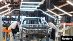 Sejumlah karyawan tampak bekerja memasang komponen mobil di pabrik mobil LADA Izhvesk, yang merupakan bagian dari produsen mobil Rusia Avtovaz, di Izhevsk, Rusia, pada 22 Februari 2022. (Foto: Reuters/Gleb Stolyarov) 