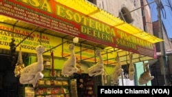 Una tienda del “Mercado de las Brujas” en La Paz, Bolivia, exhibe los característicos fetos de llama y anuncia otras mercancías "esotéricas". [Foto Fabiola Chiambi, VOA]