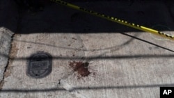 Una mancha de sangre señala el lugar en que fue baleado el periodista mexicano Armando Linares en Zitacuaro, estado de Michoacán, el 16 de marzo de 2022.