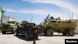 African Union peacekeepers stand next to armored personnel carriers as they provide security for members of the Lower House of Parliament who are meeting to elect a speaker, at the Aden Adde International Airport in Mogadishu, Somalia, April 27, 2022.