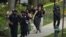 La policía evacua a las personas, incluida Sarah Cope corriendo con su perro, cerca de la escena de un tiroteo el viernes 22 de abril de 2022 en el noroeste de Washington, D.C.