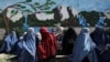 Aghan women wait to receive a food package being distributed by a Saudi Arabia humanitarian aid group at a distribution center in Kabul, Afghanistan, April 25, 2022. 