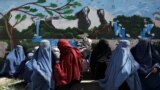 Aghan women wait to receive a food package being distributed by a Saudi Arabia humanitarian aid group at a distribution center in Kabul, Afghanistan, April 25, 2022. 