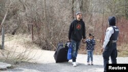 Asylum seekers cross into Canada from the U.S. border near a checkpoint on Roxham Road near Hemmingford, Quebec, April 24, 2022. 