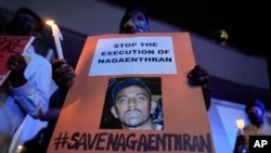 Activists hold posters against the impending execution of Nagaenthran K. Dharmalingam, sentenced to death for trafficking heroin into Singapore, during a candlelight vigil gathering outside the Singaporean Embassy in Kuala Lumpur, Malaysia, Tuesday, April