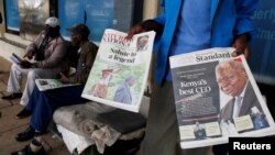 A vendor holds newspapers reporting on the death of former Kenyan President Mwai Kibaki, who died at the age of 90, in Nairobi, Kenya, April 23, 2022.