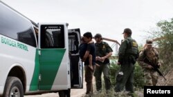 Un agente de Aduanas y Protección Fronteriza recopila información biográfica de un grupo de migrantes venezolanos antes de detenerlos cerca de la ciudad fronteriza sur de Eagle Pass, Texas, EEUU, el 25 de abril de 2022.