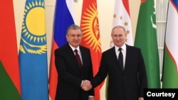 Presiden Rusia Vladimir Putin menjabat tangan Presiden Uzbekistan Shavkat Mirziyoyev dalam sebuah pertemuan di St. Petersburg, Rusia, pada 28 Desember 2021. (Foto: kremlin.ru) 