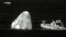In this image from infrared video provided by SpaceX, recovery personnel approach the Dragon space capsule after splashdown in the Atlantic Ocean off the Florida coast on April 25, 2022.