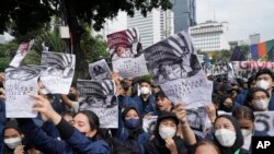 Students hold posters with portraits of President Joko Widodo during a rally in Jakarta, Indonesia, Thursday, April 21. 2022. 