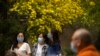 People wearing face masks gather at a public park in Beijing on April 21, 2022. The city has started testing most of its 21 million residents for COVID-19.