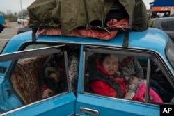 FILE - Internally displaced people from Mariupol and nearby towns fleeing from the Russian attacks, arrive at a refugee center, in Zaporizhzhia, Ukraine, April 21, 2022.