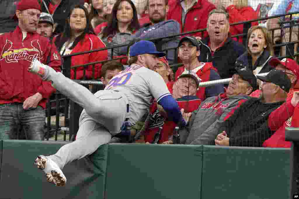 New York Mets first baseman Pete Alonso falls against netting as he catches a foul ball by St. Louis Cardinals&#39; Paul Goldschmidt for an out during the first inning of a baseball game, April 25, 2022, in St. Louis, Missouri.