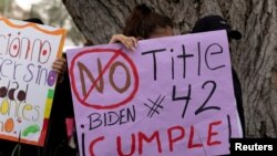 ARCHIVO. Una mujer sostiene un cartel que dice "No Title 42. Biden Cumple", en una protesta liderada por migrantes contra la orden, en Washington DC. 