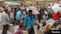 资料照片：位于也门塔伊兹的流离失所者领取一家慈善机构分发的食品援助。(2022年4月8日)