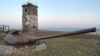 FILE - In this undated photo, a turret from an old tank rests in front of a lighthouse near Yuzhno-Kurilsk on Kunashiri Island, one of the Kuril Chain, known as the Northern Territories in Japan. The islands were seized by Soviet troops in the last days o