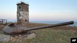 تصویری از یک تانک قدیمی در نزدیکی یک برجک در جزیره کناشیری، یکی از جزایر مورد مناقشه میان روسیه و ژاپن.