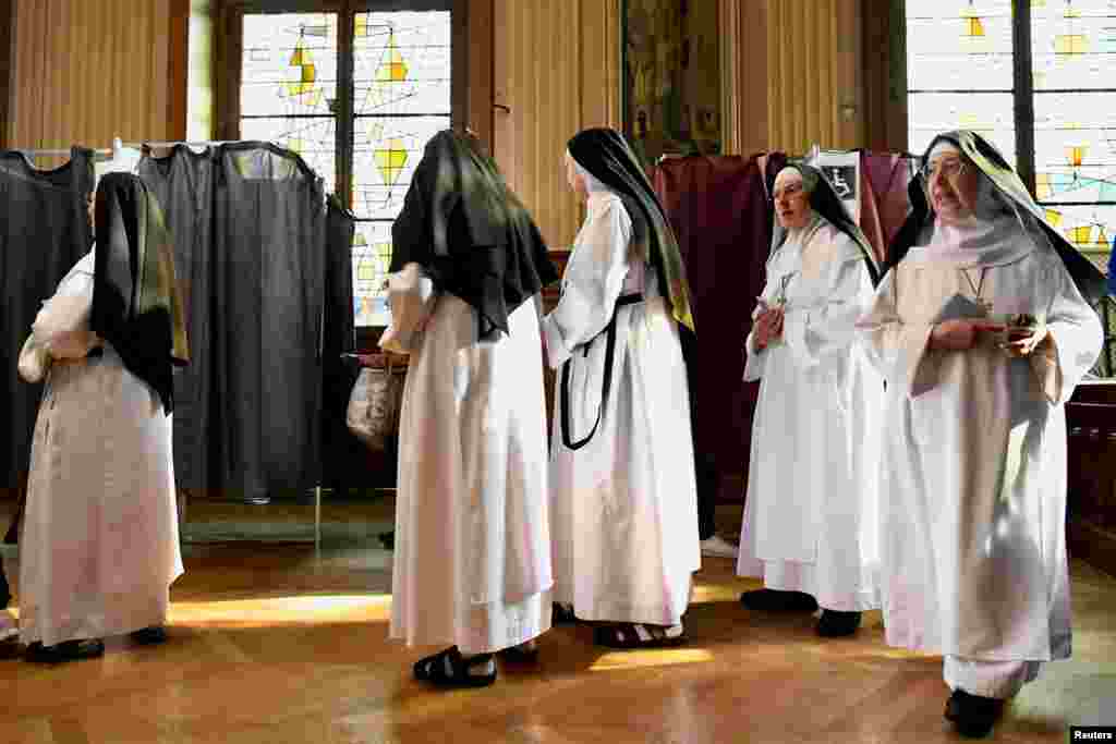 Nuns prepare to vote in the second round of the French presidential election at a polling station in Paris, France.