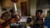 FILE - Children wait to be registered before a measles vaccination at a center in Mbata-Siala, near Seke Banza, western DRC, on March 3, 2020. 