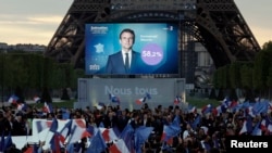 Les partisans du président français Emmanuel Macron, candidat à sa réélection, près de la Tour Eiffel, au Champs de Mars à Paris, le 24 avril 2022. REUTERS /Benoît Tessier