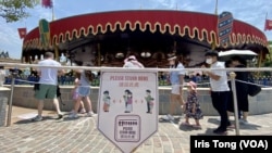香港迪士尼樂園重開後加強防疫措施，機動遊戲排隊場地上，有標示提醒遊客保持社交距離。(美國之音/湯惠芸)