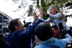 El presidente francés y candidato centrista a la reelección, Emmanuel Macron, saluda a una niña después de votar en Le Touquet, en el norte de Francia, el domingo 24 de abril de 2022.