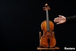 A rare 1736 violin by Italian luthier Guarneri del Gesu is displayed during a media preview at Aguttes auction house ahead of the violin's auction in Neuilly-sur-Seine, near Paris, France, April 26, 2022. (REUTERS/Benoit Tessier)
