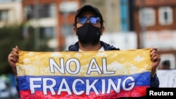 Un hombre sostiene una bandera colombiana con la frase "No al fracking" durante una protesta organizada por Miembros de Extinction Rebellion contra los proyectos piloto de fracking, en el Día de la Tierra en Bogotá. , Colombia, 22 de abril de 2022.