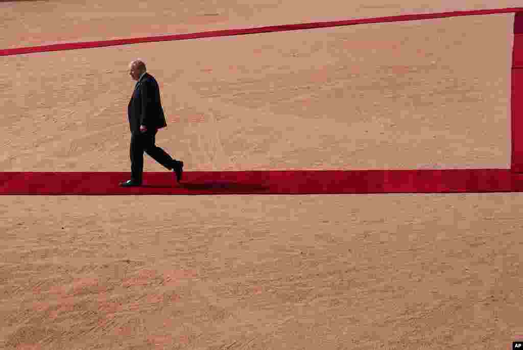 British Prime Minister Boris Johnson walks back after inspecting a joint military guard of honor at the Indian presidential palace in New Delhi. (AP Photo/Manish Swarup)