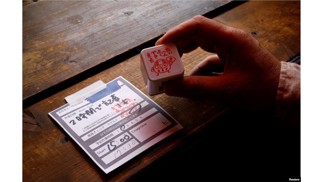 Takuya Kawai, pemilik Manuscript Writing Cafe, menunjukkan secarik kertas tempat pelanggan menuliskan tujuan dan jumlah waktu yang mereka rencanakan untuk menyelesaikan pekerjaan mereka di kafenya di Tokyo, Jepang, 21 April 2022. (REUTERS/Kim Kyung-Hoon)