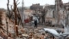 Một người đàn ông đi bộ gần các tòa nhà bị hư hại ở thành phố cảng phía nam Mariupol, Ukraine ngày 22 tháng 4 năm 2022.