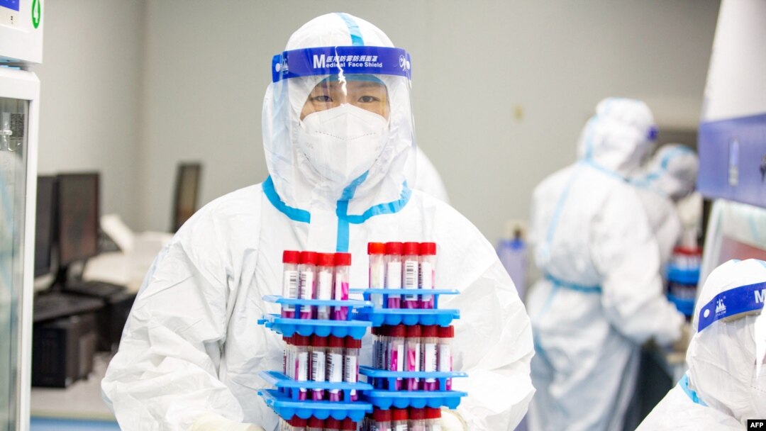 Seorang teknisi laboratorium mengenakan alat pelindung diri (APD) bekerja di laboratorium pengujian COVID-19 di Provinsi Jiangsu timur China, China, 27 April 2022. (Foto: AFP)