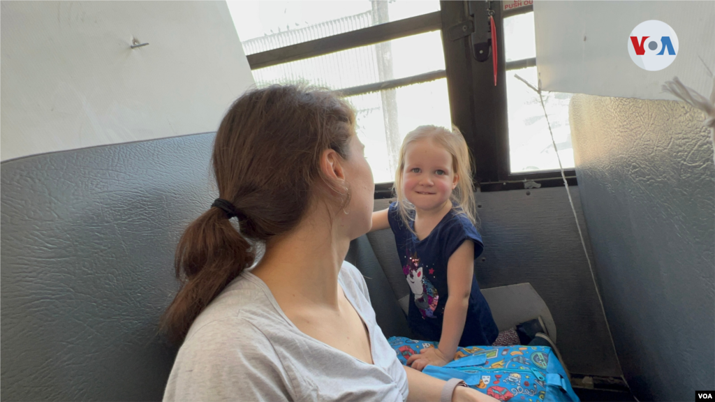 Sentada en un autobús, viaja con su mamá esta niña ucraniana, quien forma parte de uno de los primeros grupos de 50 personas que cada dos horas empiezan a salir de la Unidad Deportiva Benito Juárez a la garita de El Chaparral, abierta el 6 de abril de 2022 para procesar en Estados Unidos a los refugiados ucranianos. (Tijuana, México-April 6, 2022-Celia Mendoza)