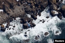 Sebuah helikopter melakukan pencarian orang hilang di atas kapal wisata "Kazu 1" di lepas pantai Semenanjung Shiretoko di Shari, Prefektur Hokkaido, Jepang, 24 April 2022. (Kyodo/via REUTERS)