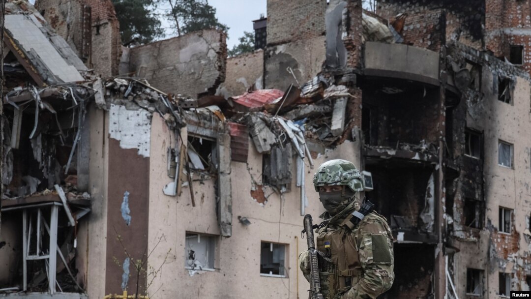 Ukrajinski vojnik blizu zgrade uništene u ruskom granatiranju, u gradu Irpin blizu Kijeva (Foto: REUTERS/Gleb Garanich)