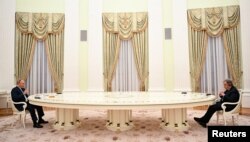 俄羅斯總統普京在莫斯科隔著一張長桌與聯合國秘書長古特雷斯交談。(2022年4月26日)