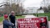 Paula and Joey Reed, orang tua dari Trevor Reed, berdiri di dekat spanduk yang bertuliskan "Bebaskan Trevor Reed" di Lafayette Square dekat Gedung Putih , di Washington, pada 30 Maret 2022. (Foto: AFP/Stefani Reynolds)