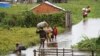 FILE - Residents wade through flood water around their homes after heavy rain in Antananarivo, Madagascar, Jan. 19, 2022. 