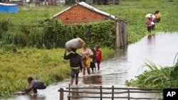 FILE - Residents wade through flood water around their homes after heavy rain in Antananarivo, Madagascar, Jan. 19, 2022. 