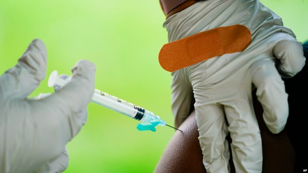 A health worker gives a dose of COVID-19 vaccine in Reading, Pa. COVID-19 vaccinations are at a critical juncture as companies test whether new approaches can keep up with a mutating coronavirus — even though it’s not clear if any change is needed. (AP Photo/Matt Rourke, File)