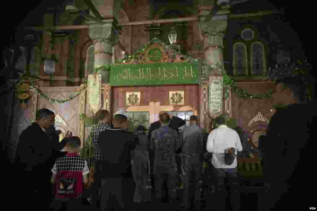 For the first time since Egypt imposed pandemic closures and tight restrictions on places of worship, Muslims gather at a shrine inside the historic Al-Sayeda Zainab Mosque, in Cairo, April 17, 2022. (H. Elrasam/VOA)